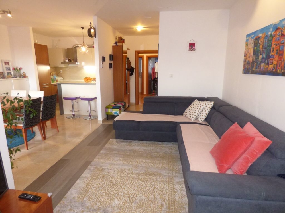 The living room and a view of the kitchen with dining area.