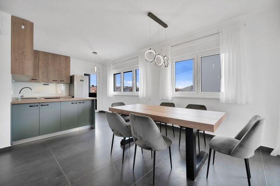 Open kitchen with dining table and window front