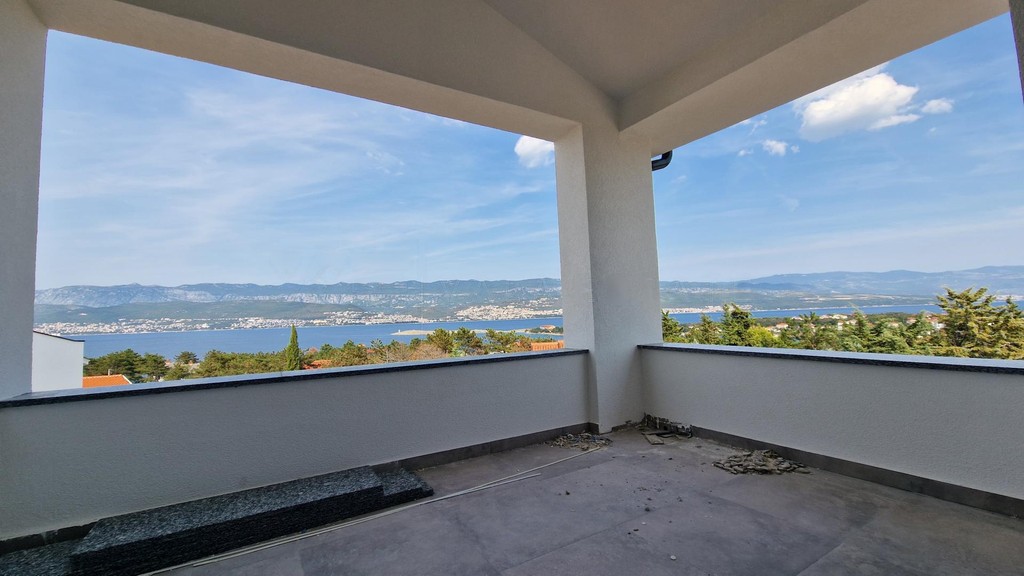 Covered terrace with balustrade and a view over the bay and coastline