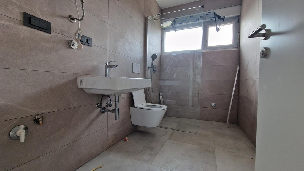 Bathroom with washbasin, wall-hung WC and level-access shower