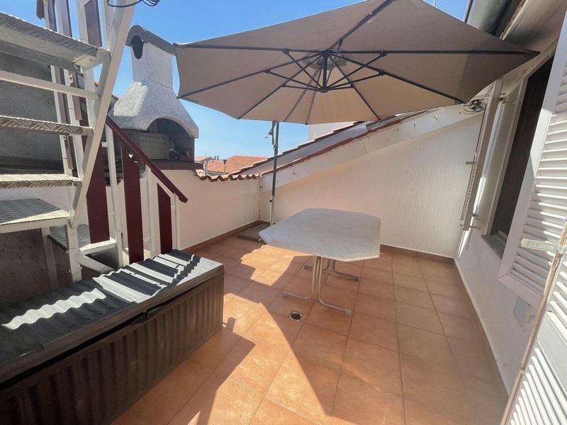 Terrace with parasol and outside staircase by the chimney