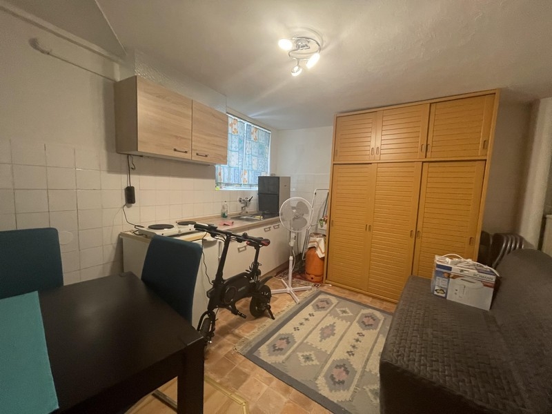 Kitchenette with yellow cupboard and rug