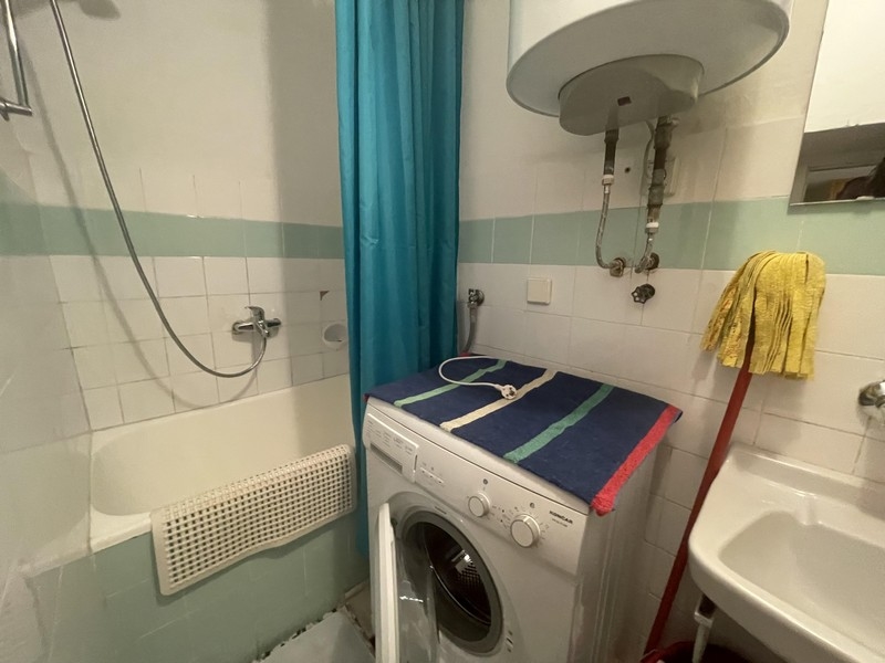 Bathroom with bathtub, shower curtain and washing machine