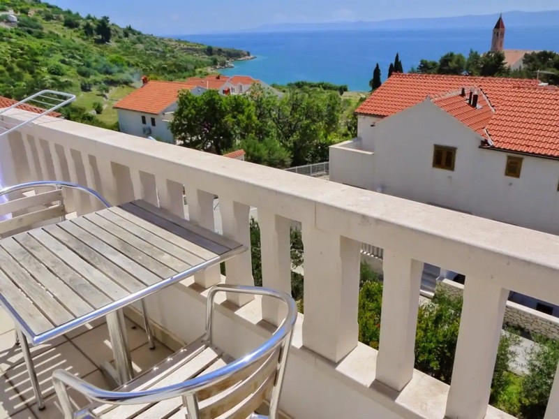 Balcony overlooking the green landscape and the sea from property A2999 in Croatia on the island of Brac.