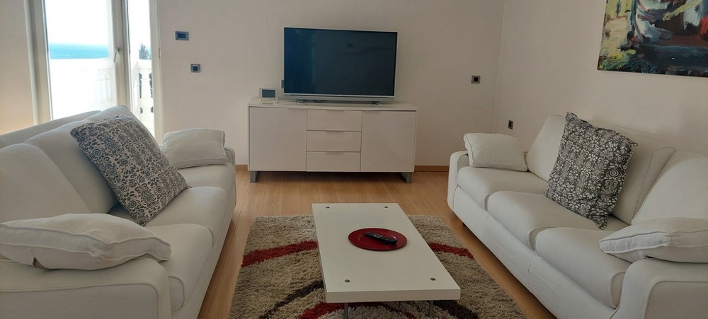 Bright living room with access to the balcony and sea views