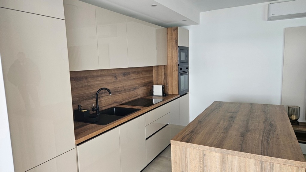 Open plan kitchen and dining area with sea views in a penthouse for sale in Zadar, Croatia