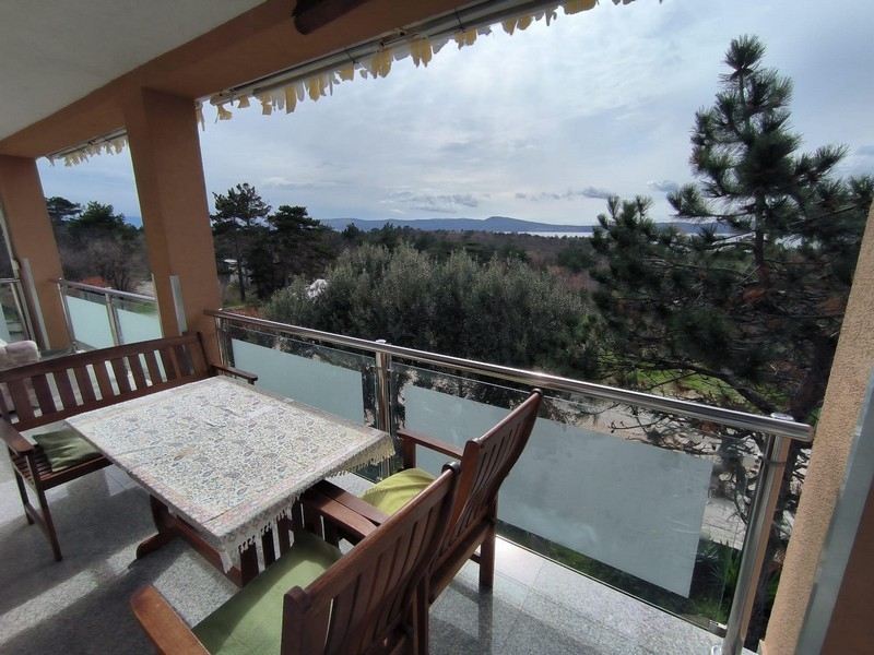 Spacious, covered terrace of an apartment in Croatia with dining area and sea views.