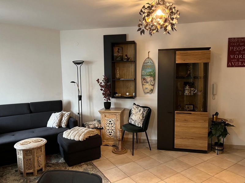Living area with display cabinet, wall shelf and floor lamp