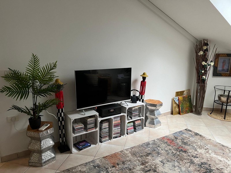 Television on white storage boxes with CDs and decorative figurines