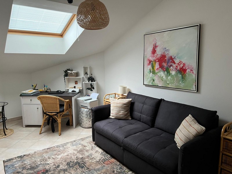Workspace and sofa in the attic with skylight