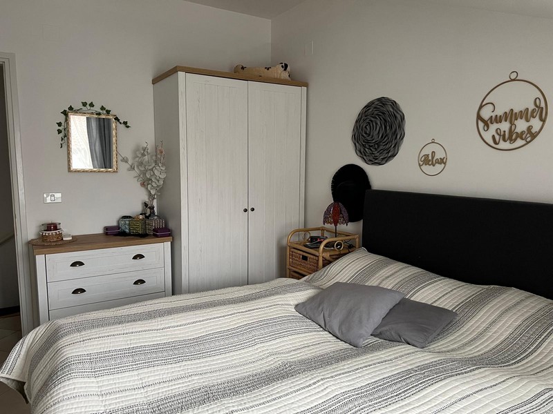 Bedroom with double bed, chest of drawers and white wardrobe