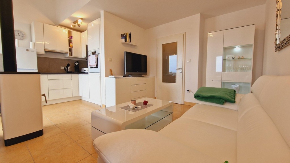 Bright and modernly furnished living room and view into the open kitchen of property A3459 in Malinska, island of Krk.