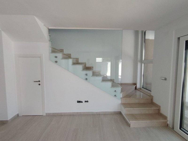 Modern stairs with glass railings in maisonette apartment