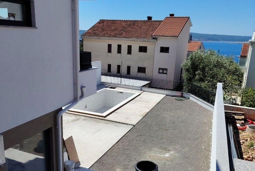 Outside with pool and sea view in the background