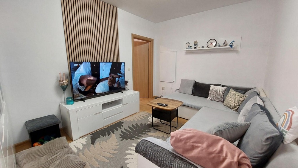 Bright living room with large sofa and TV