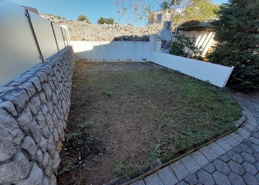 Small garden area with stone wall and lawn