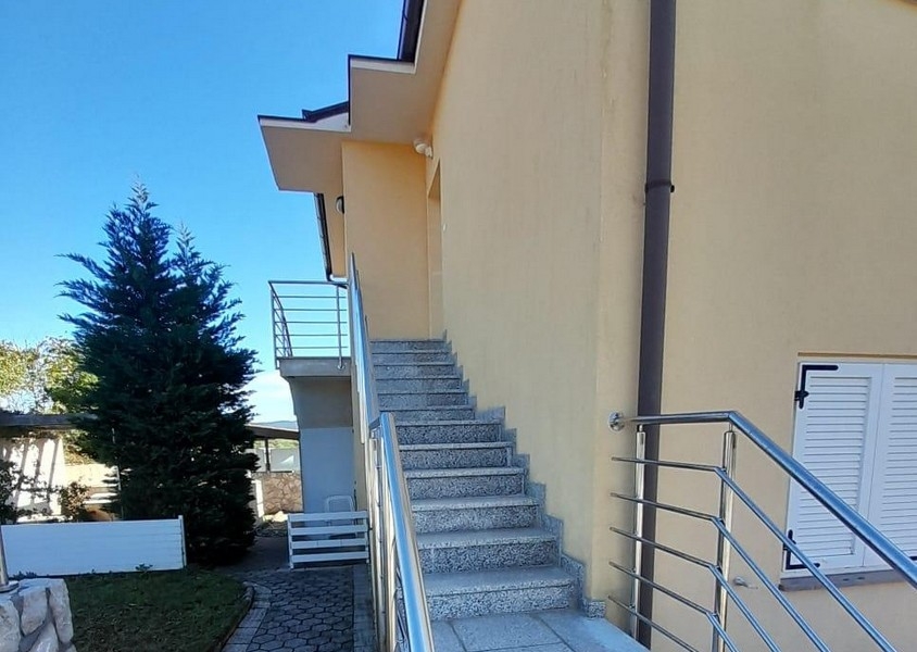 External stairs to the apartment entrance with stainless steel railings
