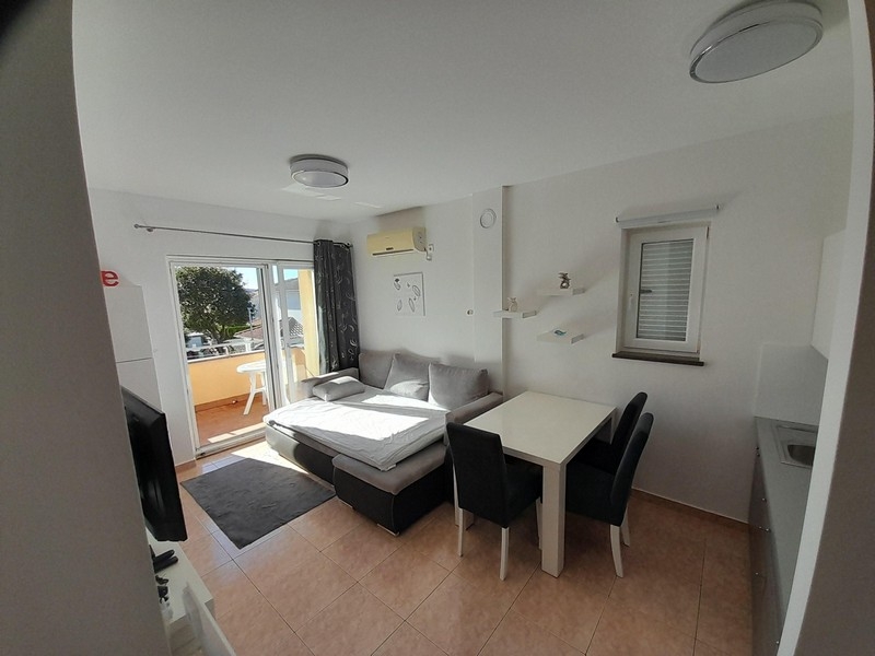 Living area with sofa, dining table and access to the balcony with sea views