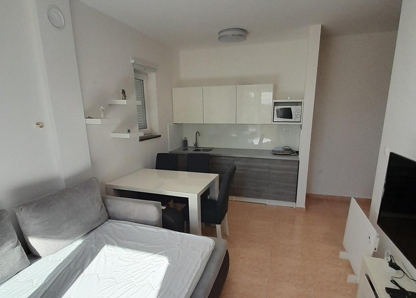 Modern kitchenette with upper and lower cabinets and dining area