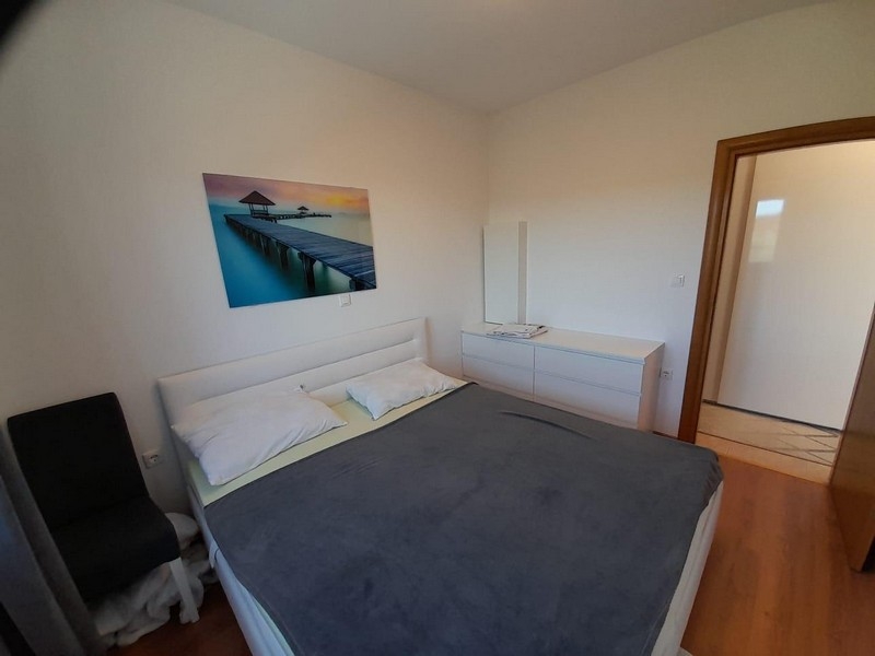 Bedroom with double bed, chest of drawers and mirror