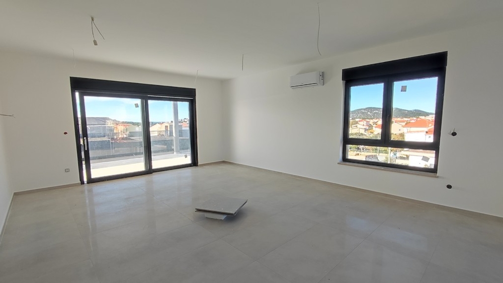 Living room with two windows and preparation for kitchen