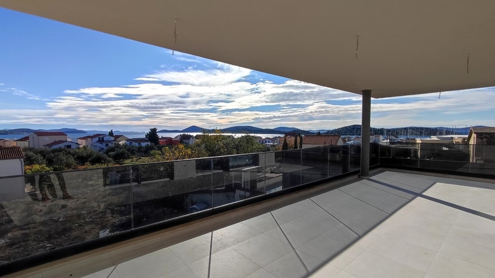 Large covered terrace with views of the rooftops and the sea
