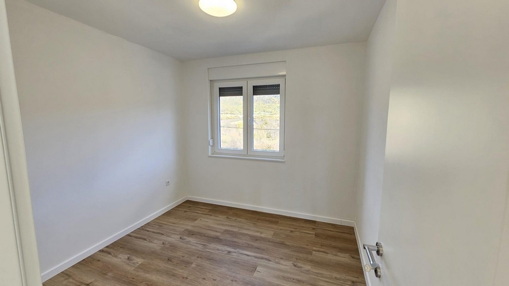 Bedroom with window and wooden floor