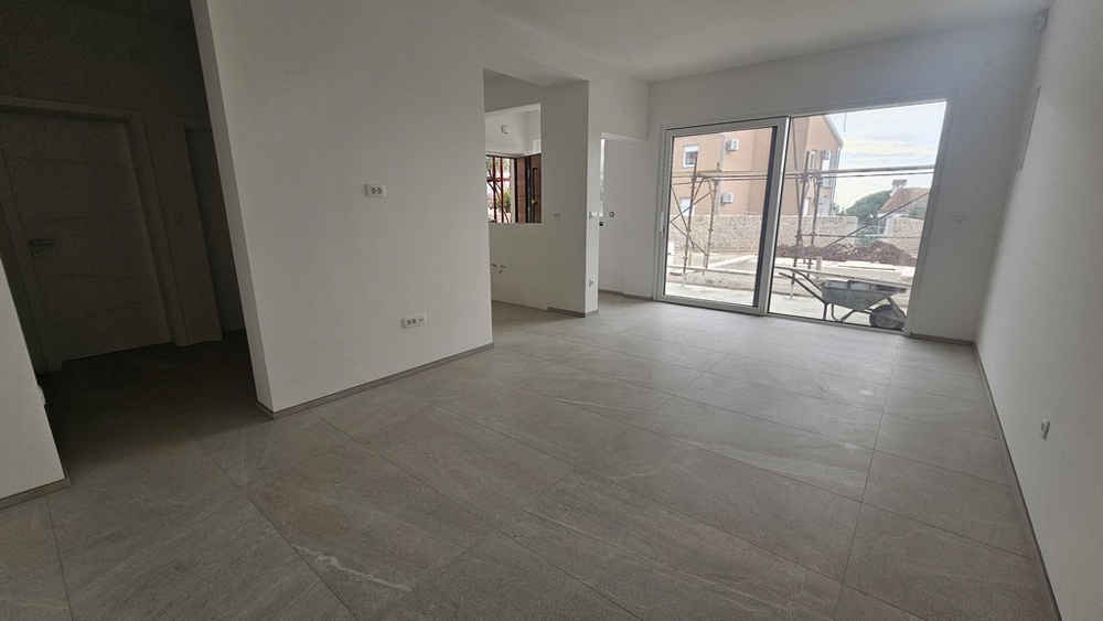 Living room with terrace access and large floor tiles