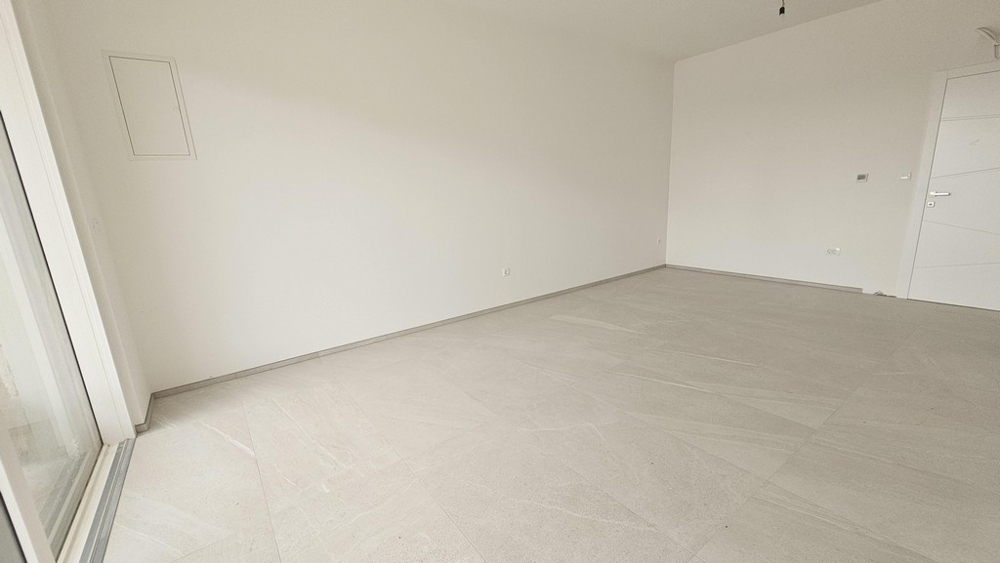 Bedroom with light walls and tiled floors