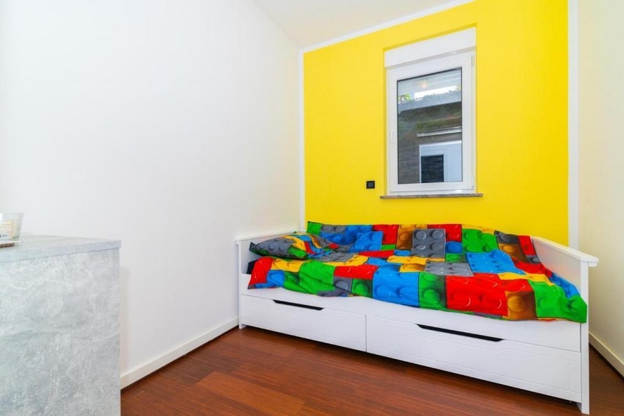 Second bedroom with single bed and colored wall