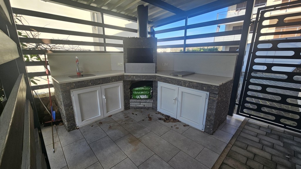 Covered outdoor kitchen with barbecue area