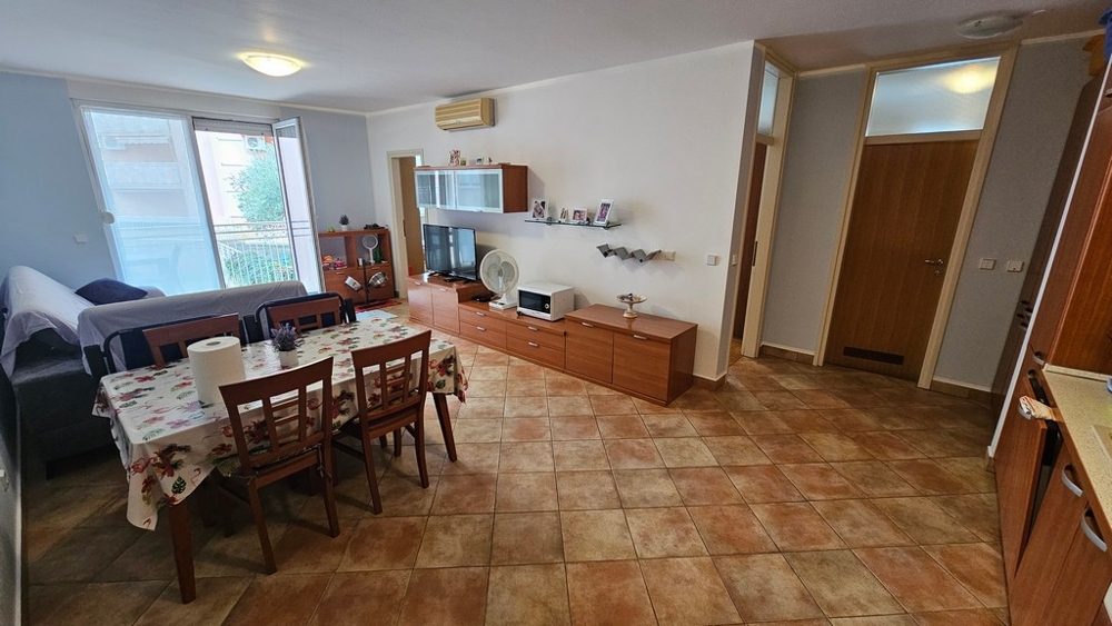 Living and dining area with open kitchen and balcony access