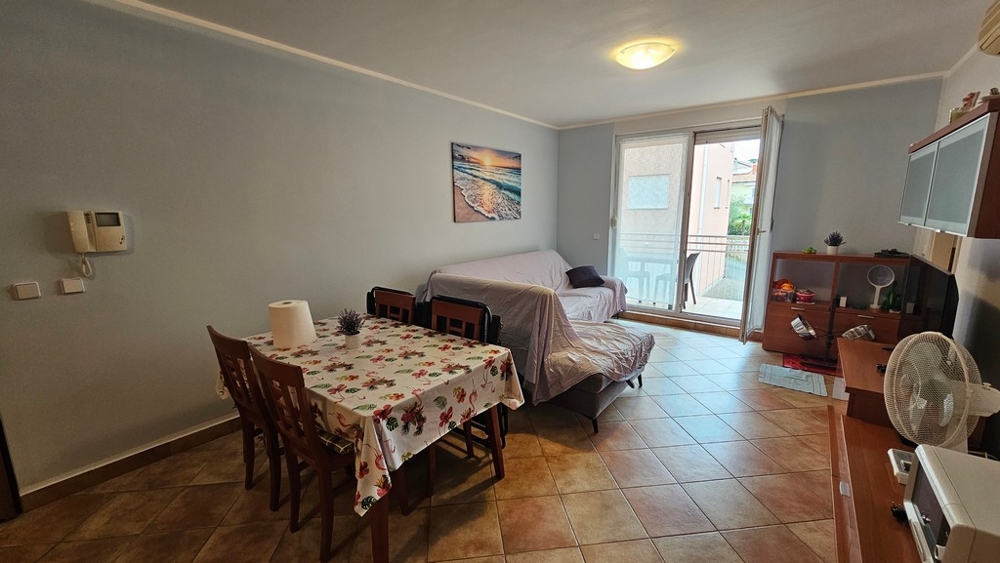 Living room with sofa, dining area and access to the terrace