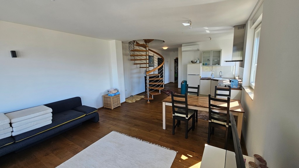 Open living and dining area with kitchen and spiral staircase