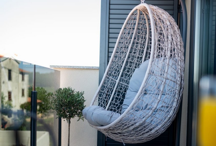 Hanging chair on balcony with glass railing