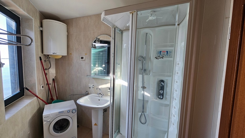 Bathroom with shower, washing machine and window
