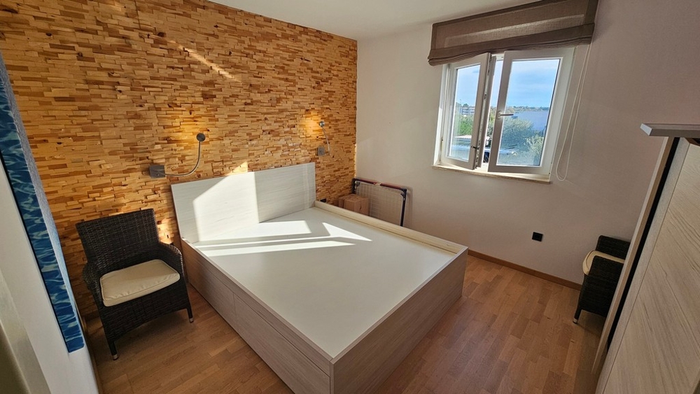 Bedroom with wooden accent wall and ocean view