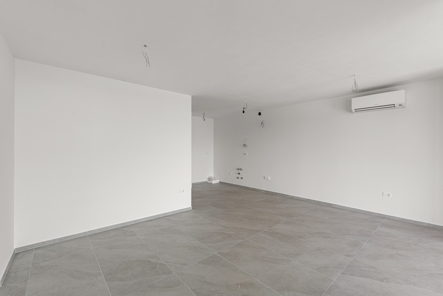 Open plan living area with kitchen connections and air conditioning