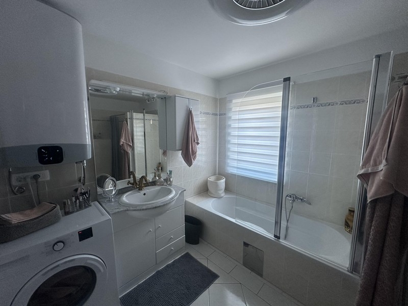 Bathroom with bathtub, sink and washing machine