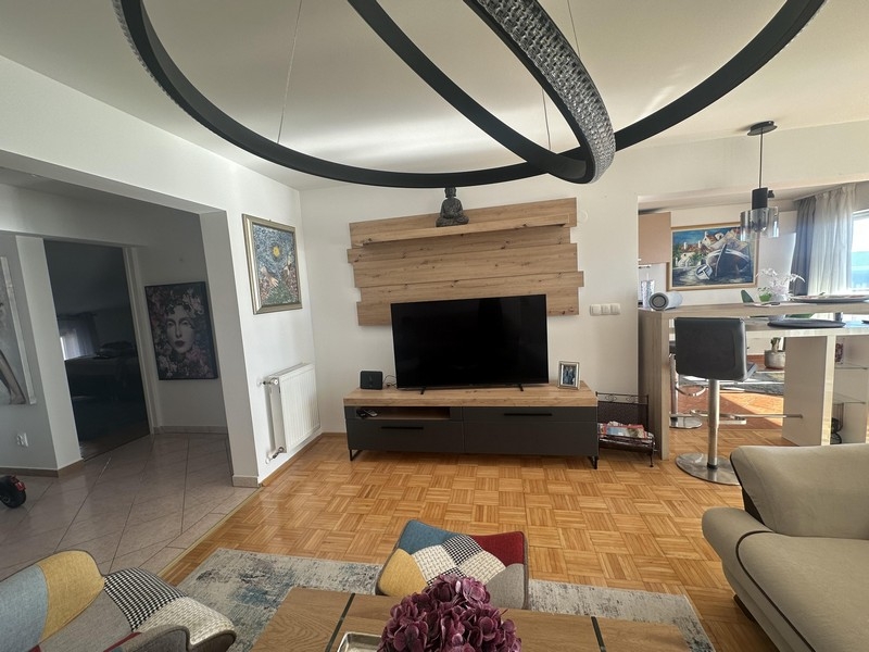 Living room with TV area and passage to the kitchen