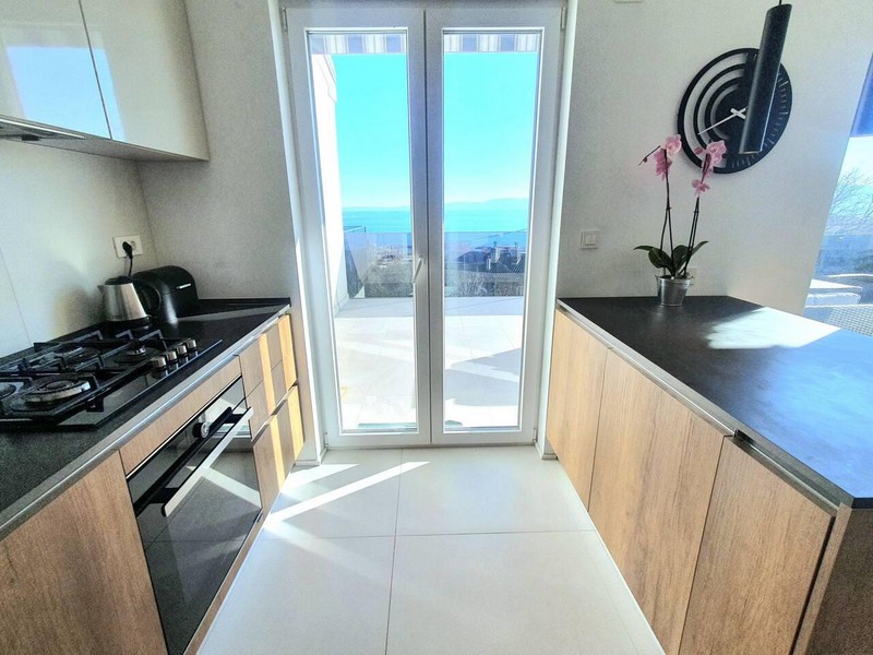 Kitchen with orchid and terrace door to the sea