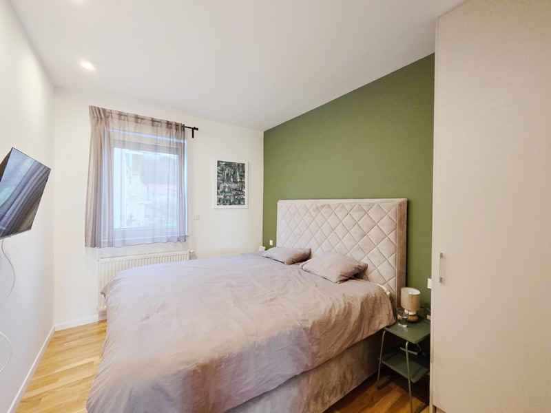 Bedroom with double bed and green feature wall