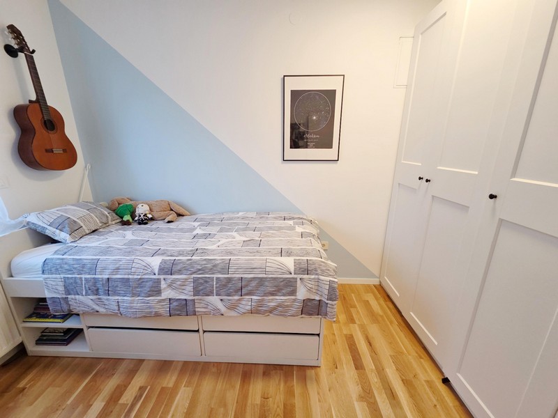 Children's bedroom with bed, guitar and wardrobe