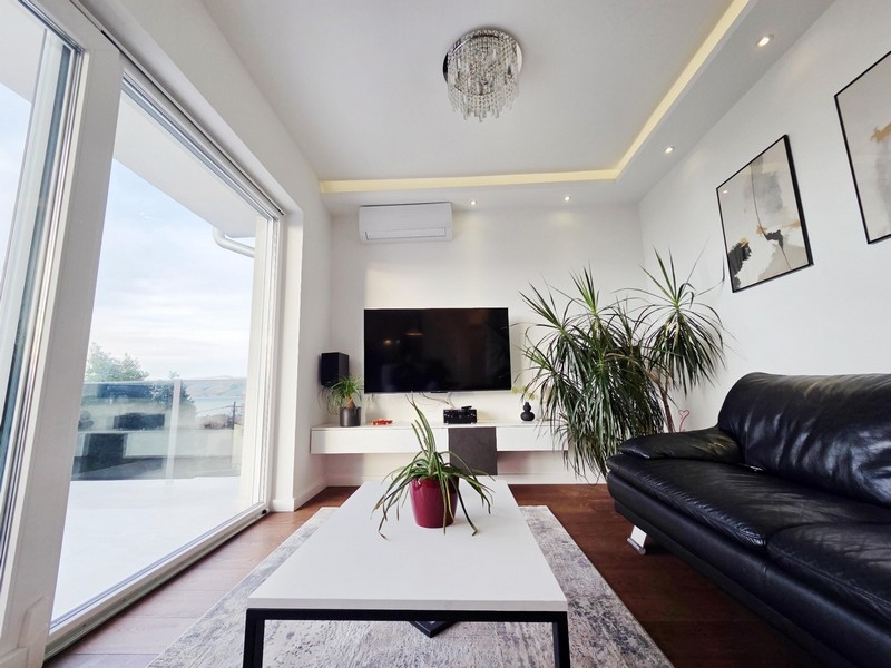 Living room with large glass front and access to the terrace with sea views