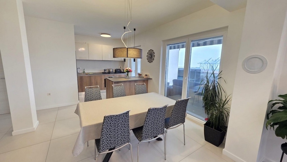 Dining area with table and six chairs and access to the terrace