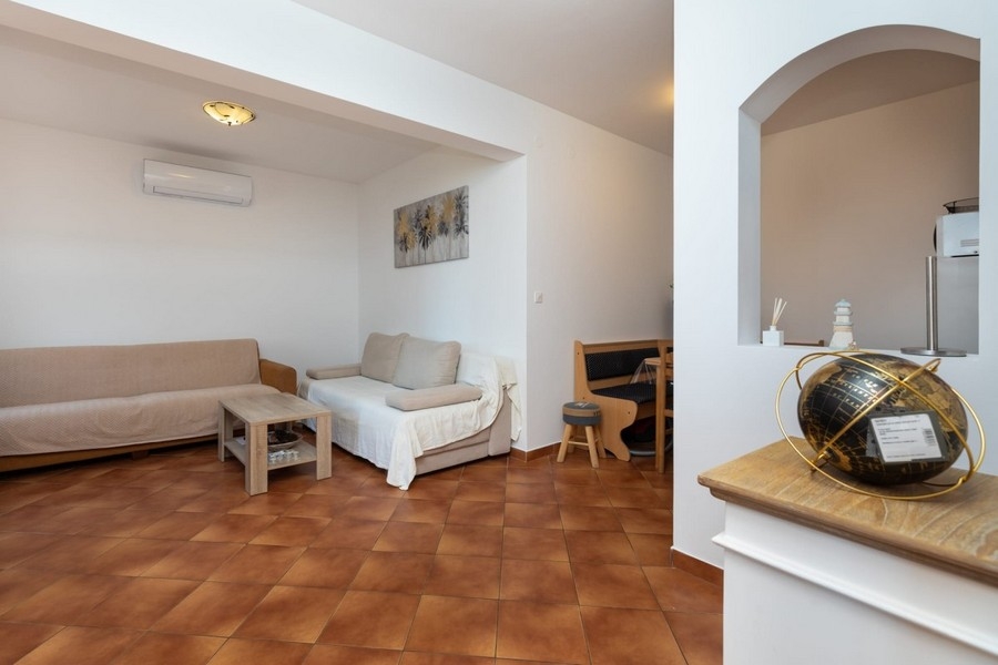 Living area of ​​the apartment with seating and passage to the kitchen