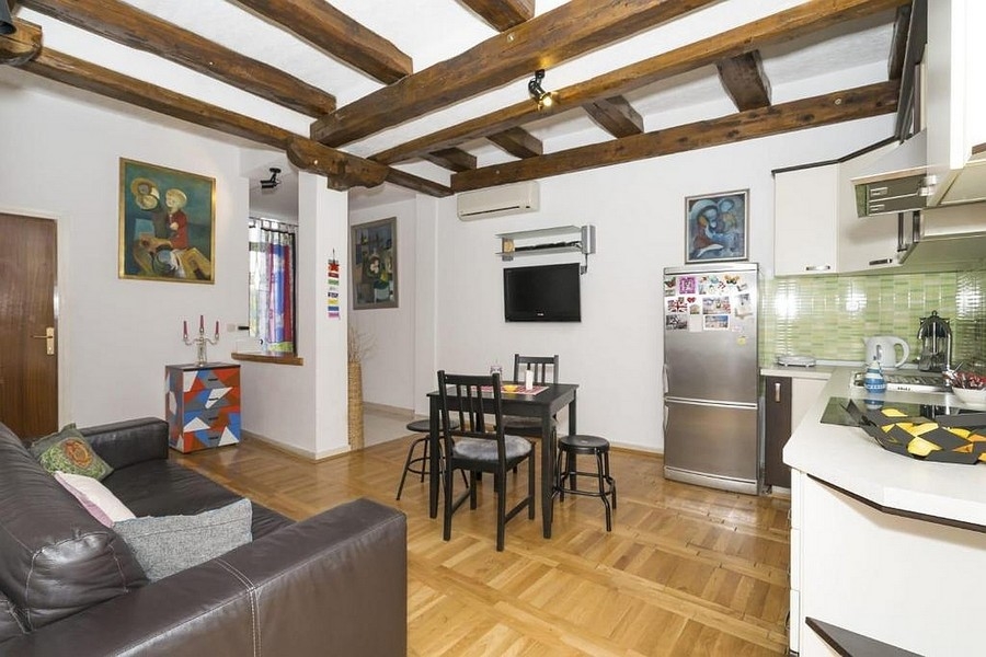 Living area with kitchen and dining area and wooden beamed ceiling