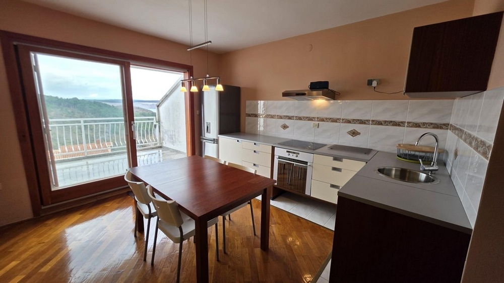 Living area with integrated kitchenette and view of the terrace.