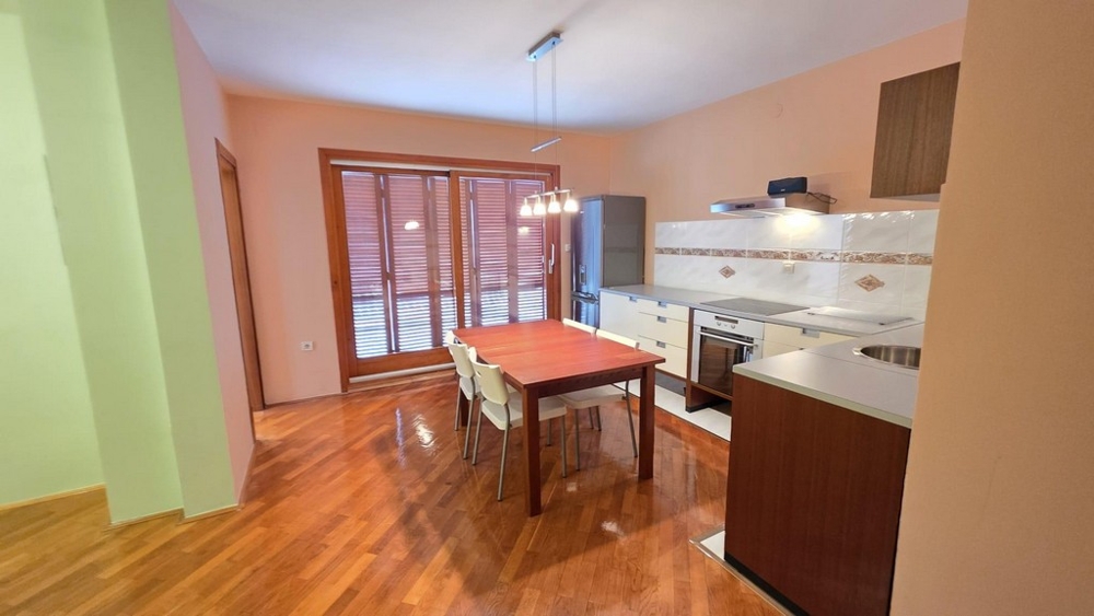 Living area with kitchen and dining table and access to the balcony