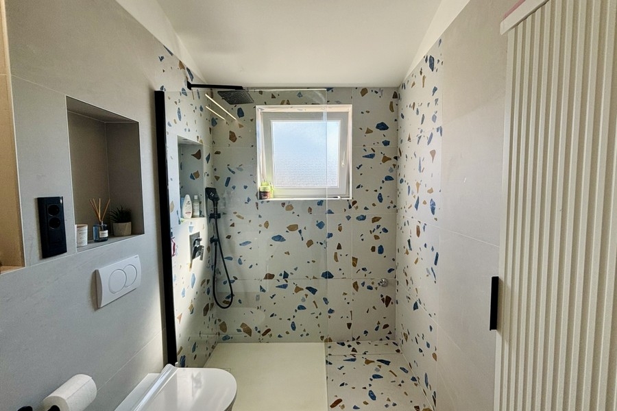 Modern bathroom with floor-level shower and window